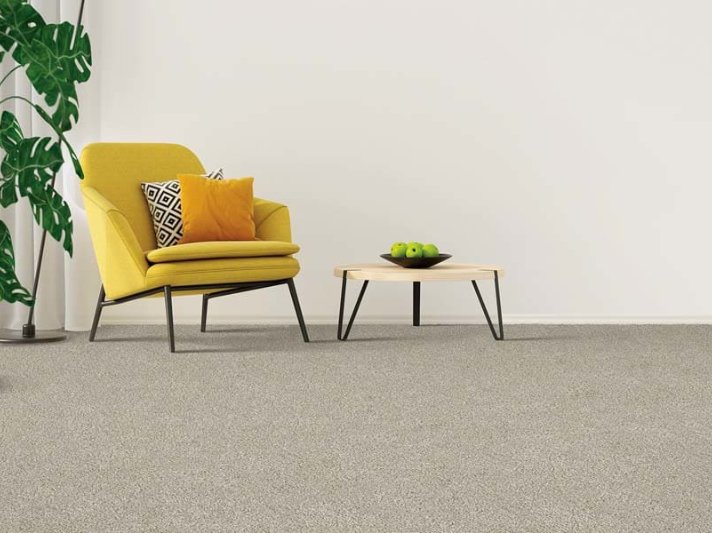 Grey carpet flooring in an open room with a yellow armchair