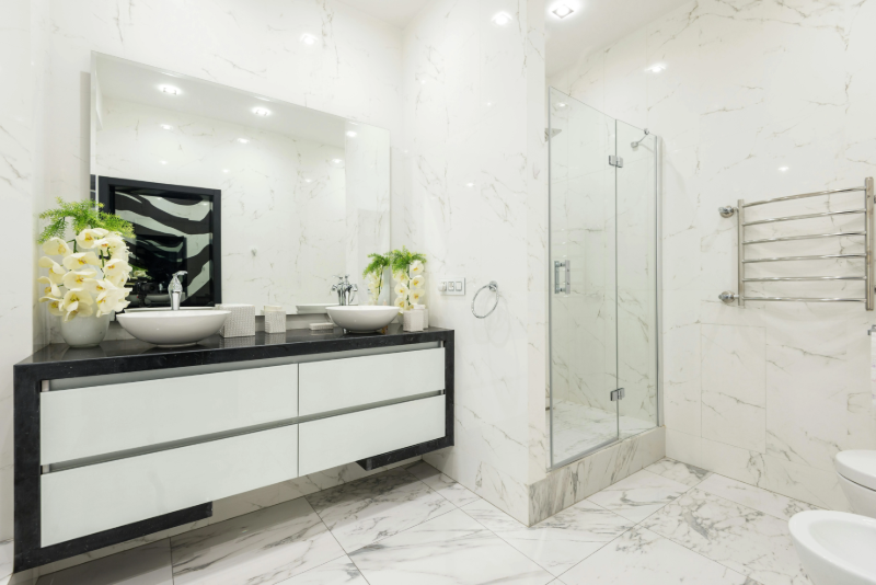 Luxury bathroom with white marble tile flooring and walls