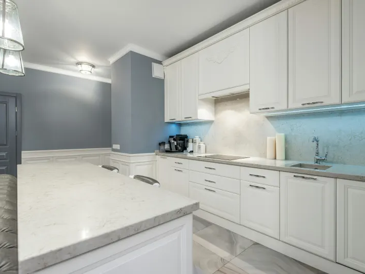 Granite countertop in a compact kitchen with white cabinets