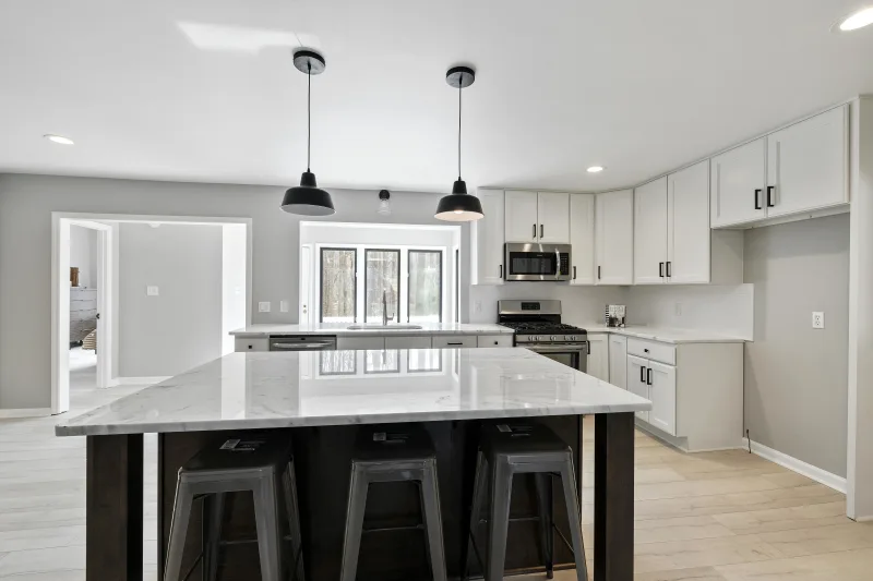 Bright kitchen with marble countertops and white cabinets