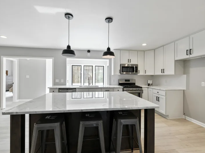 Bright kitchen with marble countertops and white cabinets