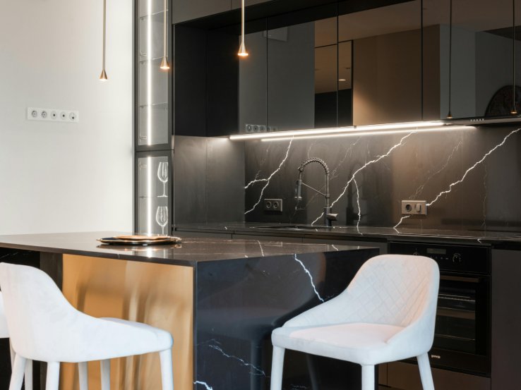 Modern kitchen with black marble counters and backsplash